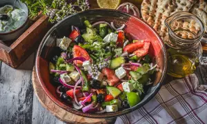 Frischer griechischer Salat mit Feta, Tomaten, Gurken, Oliven und Zwiebeln in einer Schüssel.