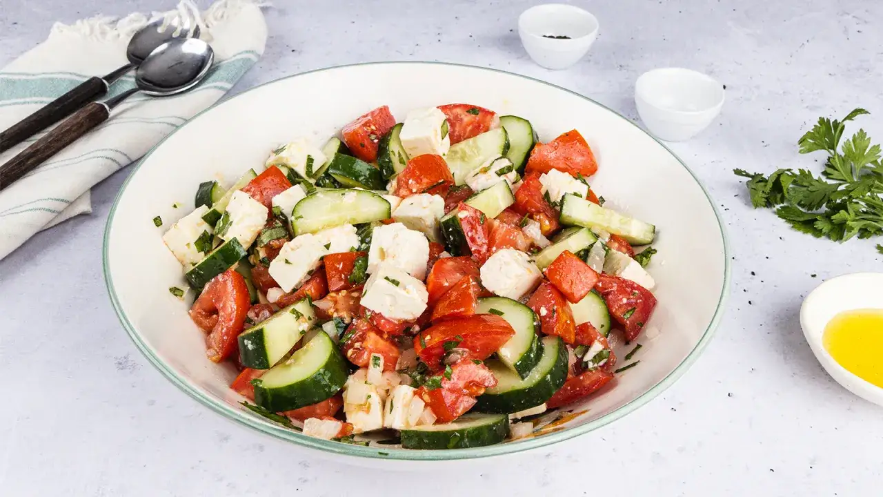 Tomaten-Gurken-Salat mit Feta als Beilage zu gegrilltem Fleisch