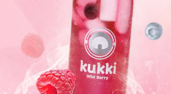 Kukki Wild Berry Drink mit Himbeeren und Blaubeeren auf pinkem Hintergrund.